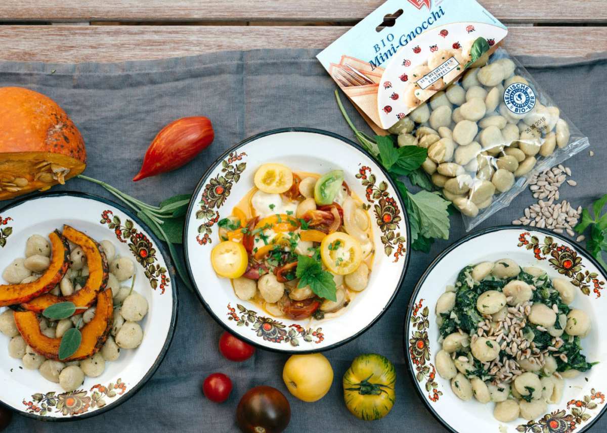 Verschiedene Gnocchi-Gerichte, daneben eine Packung Ja! Natürlich Bio Mini-Gnocchi.