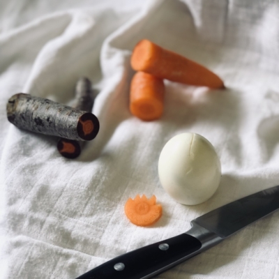 Bio-Karotten, Eier und ein Messer auf einem Tuch.