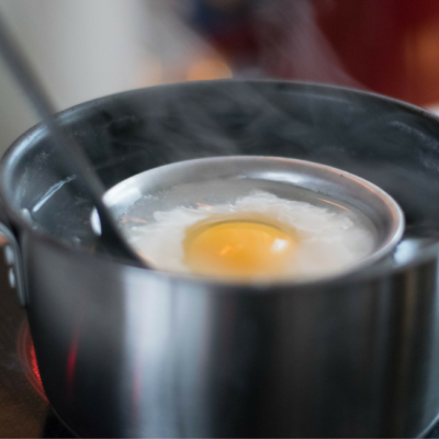 Jemand kocht ein Ei in einem Suppenlöffel.