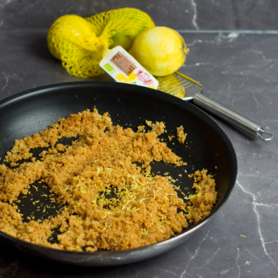 Eine Pfanne mit angerösteten Bio-Dinkelbröseln und Zitronenzeste.