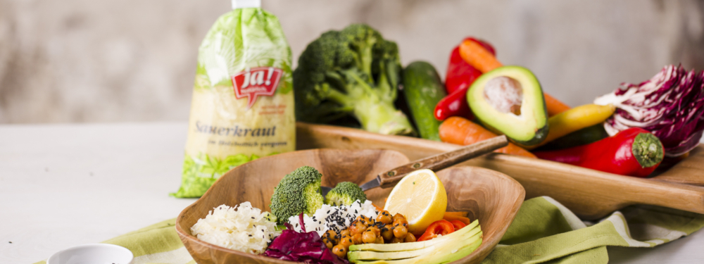 Ein Gericht mit Ja! Natürlich Bio-Sauerkraut in einer Holzschüssel angerichtet.