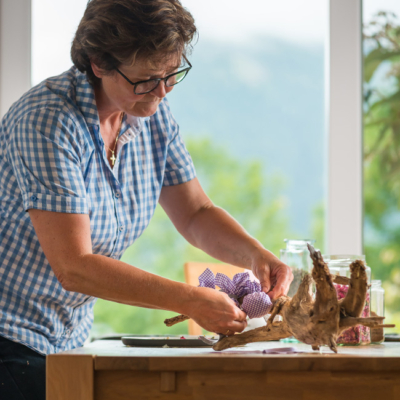 Andrea Rieder befestigt Säckchen mit Räuchermischungen an einen Wurzelstock.