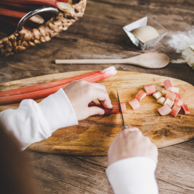 Jemand schneidet Bio-Rhabarber.