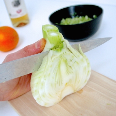 Jemand schneidet Bio-Fenchel.