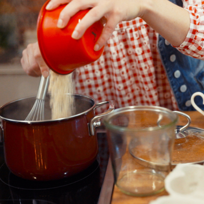 Jemand gießt Bio-Grieß in einen Topf.