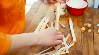 Jemand schält Bio-Spargel.