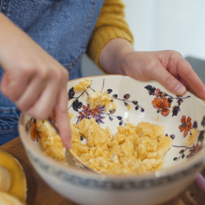 Jemand zerdrückt Bio-Bananen in einer Schüssel.