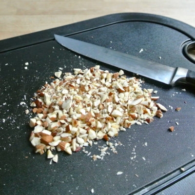 Gehackte Bio-Mandeln auf einem Brett.