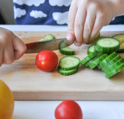 Jemand schneidet Bio-Gurken.