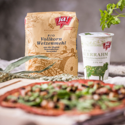 Vollkorn-Flammkuchen, dahinter Ja! Natürlich Bio-Vollkorn-Weizenmehl und Sauerrahm.