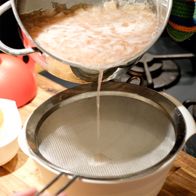 Jemand siebt den Rhabarbersirup.