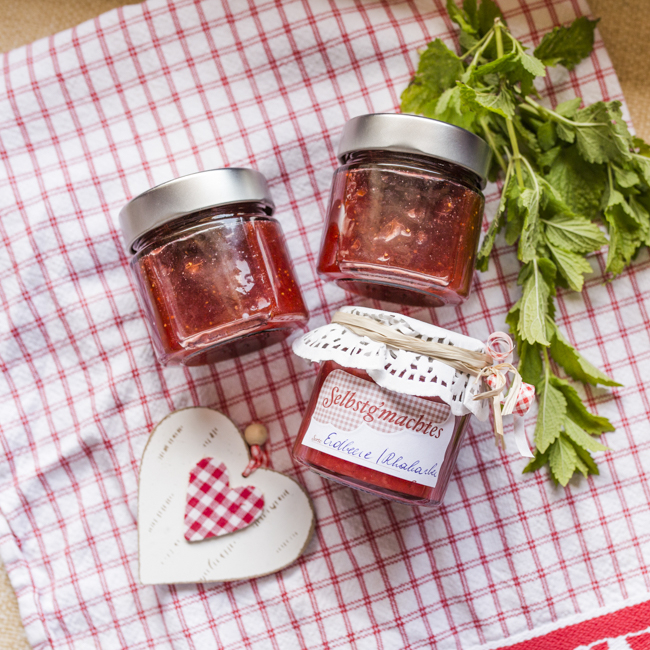 Drei Marmeladengläser auf einem Tisch.