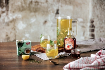 Pfefferminz-Eistee in einem Krug und in zwei Gläsern auf einem Tisch.