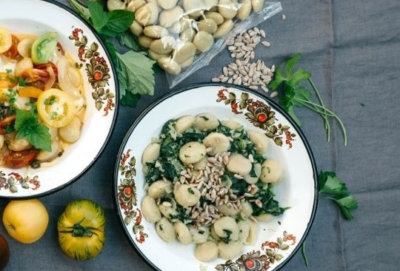 Ein Teller mit Bio-Gnocchi mit Blattspinat und Sonnenblumenkernen.