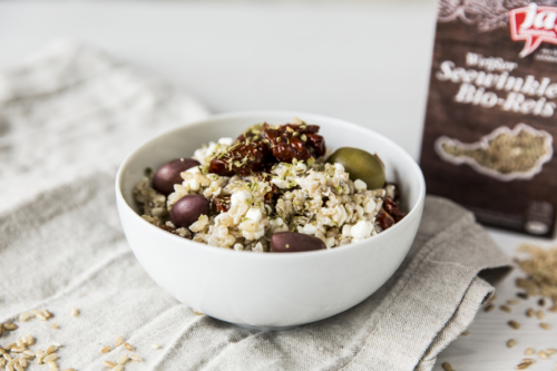 Eine Schüssel Ja! Natürlich Bio-Weißer Seewinkler Reis mit Cottage Cheese, getrockneten Paradeisern und Oliven.