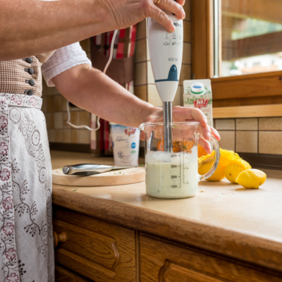Jemand püriert den Fitnesstrunk in einem Messbecher.