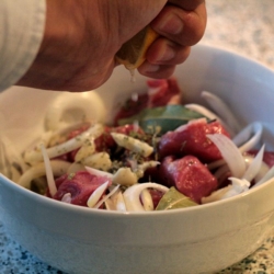 Jemand macht einen griechischen Bio-Fleisch-Gemüse-Eintopf.