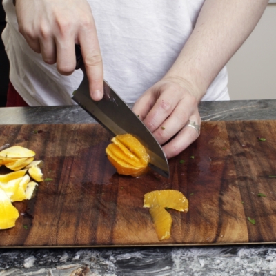 Jemand schneidet Bio-Orangen.