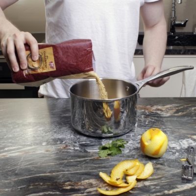 Bio-Hirse wird in einen Topf geschüttet.