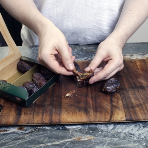 Jemand entkernt Bio-Datteln.