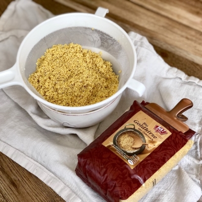 Ja! Natürlich Bio-Goldhirse in einem Sieb.
