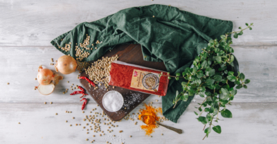 Eine Packung Ja! Natürlich Bio-Linsenteller auf einem Brett mit weiteren Zutaten für einen Linsendip.