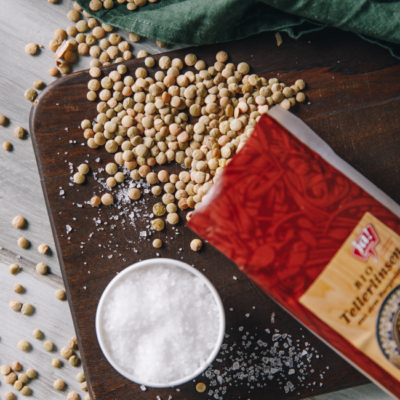 Ja! Natürlich Bio-Tellerlinsen auf einem Holzbrett, daneben ein Schälchen Salz.