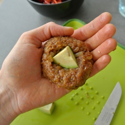 Ein Stück Bio-Avocado in der Mitte eines Fleischbällchens.
