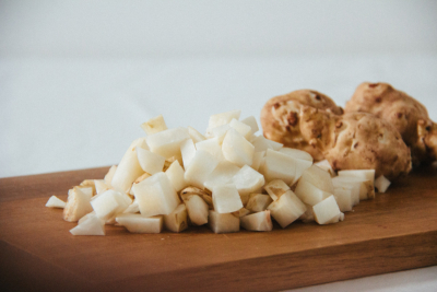 Geschnittener Bio-Topinambur auf einem Brett.