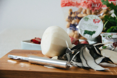 Ein geschälter Winterrettich auf einem Brett, im Hintergrund Ja! Natürlich Bio-Crème Fraîche.