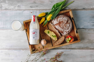 Ein Tablett mit Ja! Natürlich Bio-Vollmilch und Brot, Ei und Gemüsesticks.
