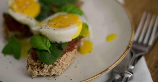 Selbstgebackenes Brot mit Tomatenaufstrich und pochierten Eiern