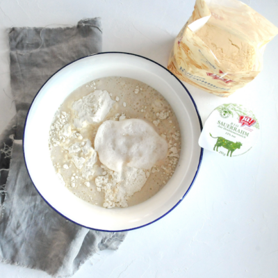 Eine Schüssel mit Mehl und Ja! Natürlich Bio-Sauerrahm.