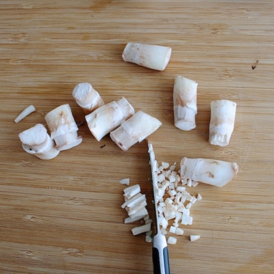 Bio-Champignonstiele auf einem Schneidebrett.