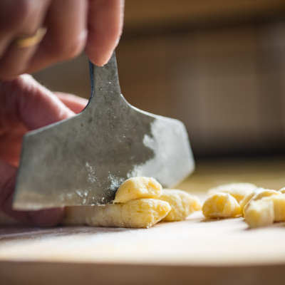 Jemand sticht Gnocchi aus einem Bio-Teig.
