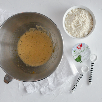 Eine Schüssel mit Bio-Eiern, daneben ein Becher Ja! Natürlich Bio-Crème fraîche und eine Schüssel Mehl.