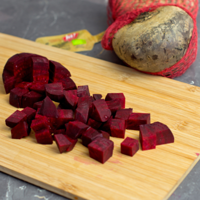 Würfel aus roter Bio-Rübe auf einem Holzbrett.