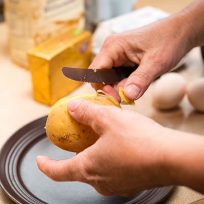 Jemand schält Bio-Erdäpfel.