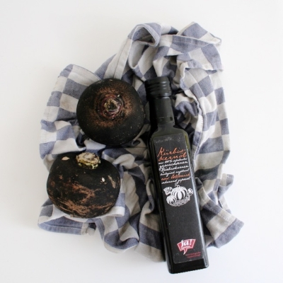 Eine Flasche Ja! Natürlich Bio-Kürbiskernöl neben schwarzem Bio-Rettich.