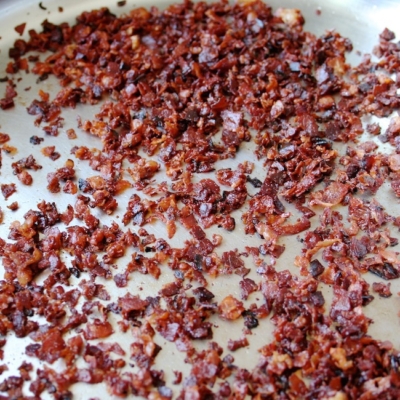 Gebratener Bio-Speck liegt in einer Pfanne.