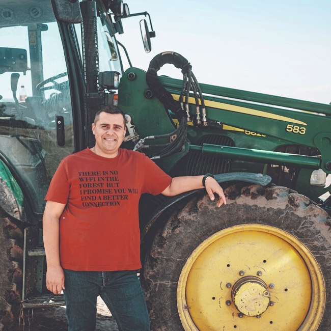 Bio-Süßkartoffel Bauer Andreas Sam neben dem Traktor- Ja! Natürlich