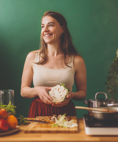 Ernährung im Einklang mit dem Zyklus, Frau beim Kochen mit Karfiol in der Hand - Ja! Natürlich