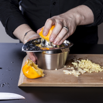 Jemand presst eine Bio-Orange aus.