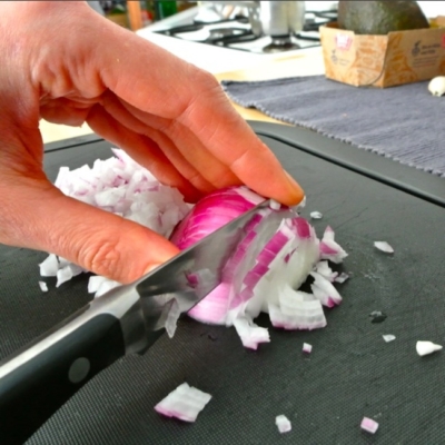 Jemand schneidet Bio-Zwiebel.