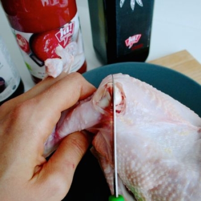 Jemand schneidet ein Bio-Huhn.