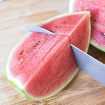 Jemand schneidet eine Bio-Wassermelone.