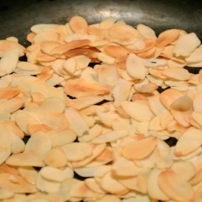 Geröstete Bio-Mandelblätter in einer Pfanne.