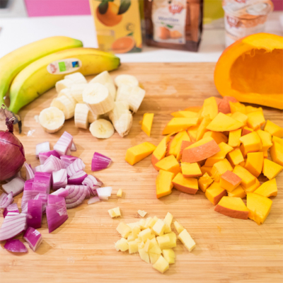 Geschnittenes Bio-Obst und Gemüse auf einem Schneidebrett.