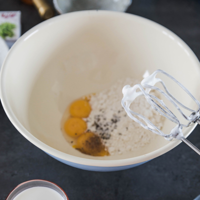 Jemand mixt Bio-Eier und Mehl mit dem Stabmixer.