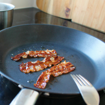 Bio-Speck wird in der Pfanne gebraten.